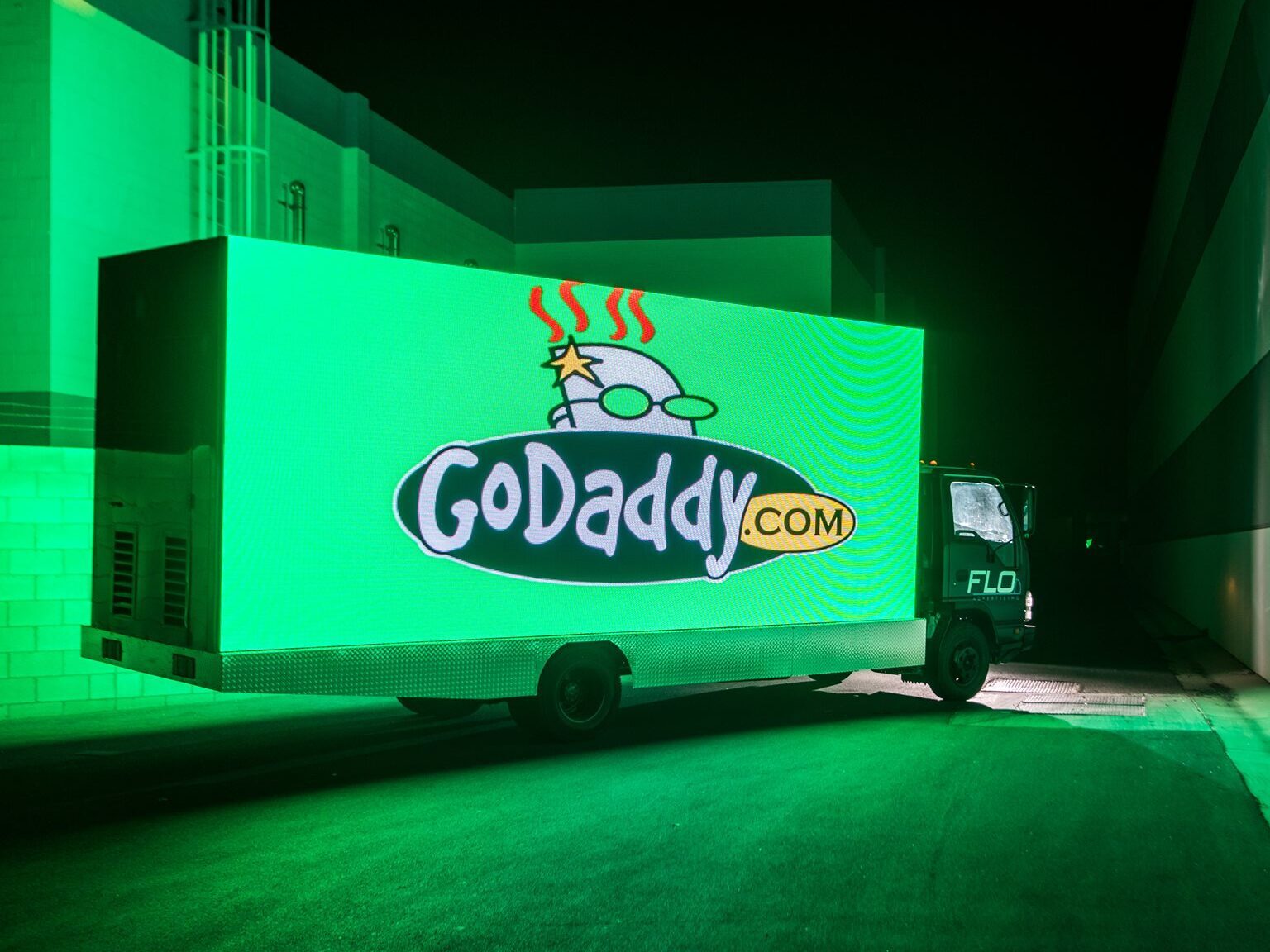 A billboard truck with a GoDaddy logo on it.