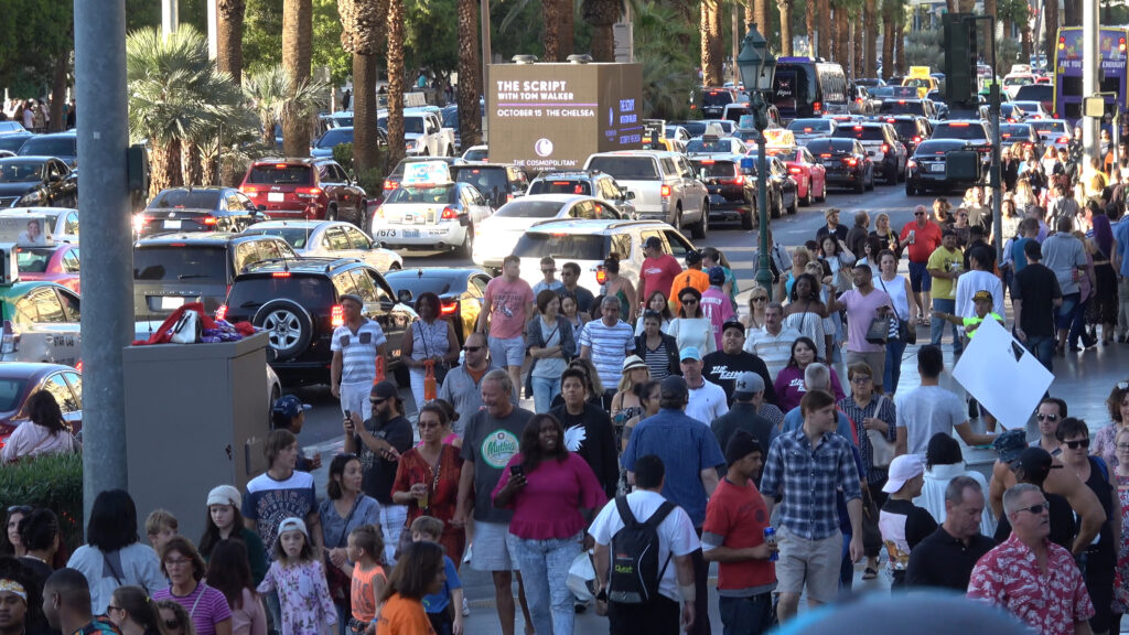 A street in Las Vegas with a lot of people and traffic.