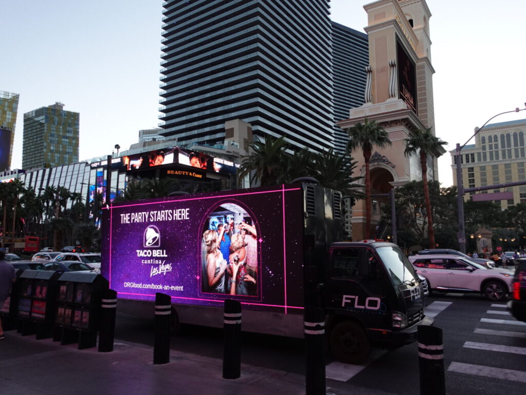taco bell ad on a mobile billboard truck in front of cosmo hotel in las vegas
