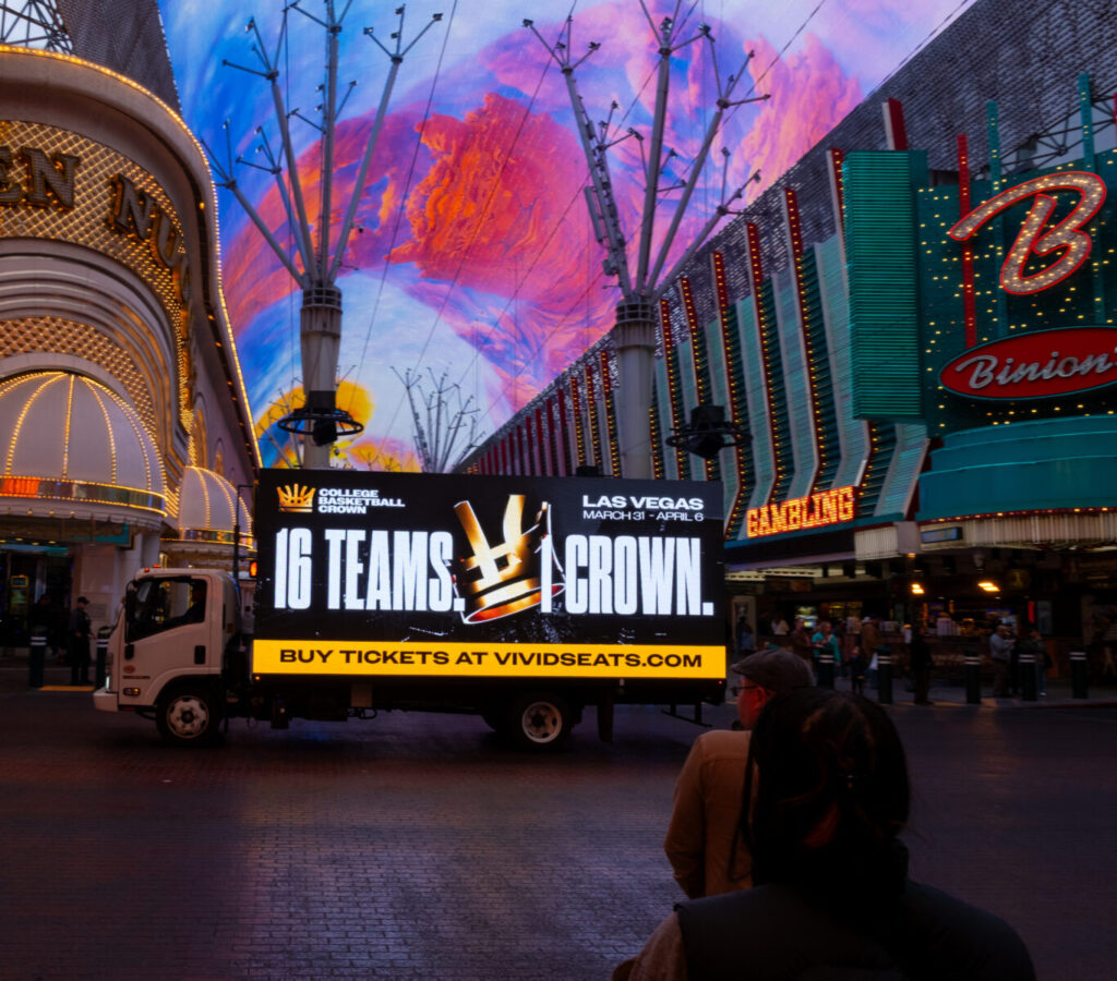 College Basketball Crown ad on billboard truck driving on Fremon Street.